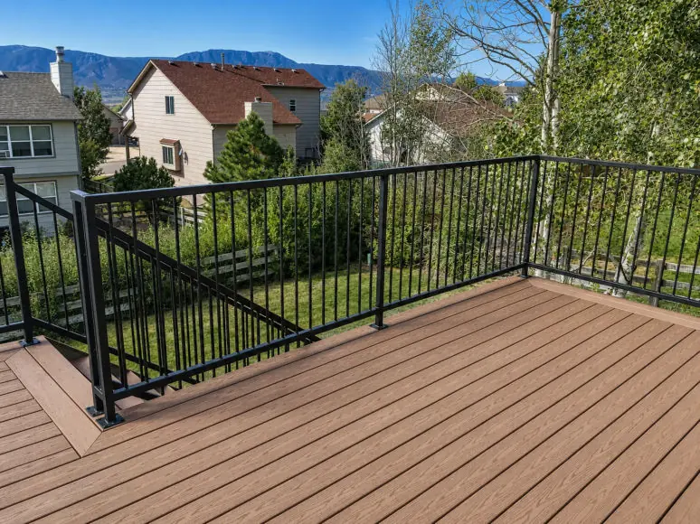 Classic railing with evenly spaced vertical pickets on a composite deck with mountain views