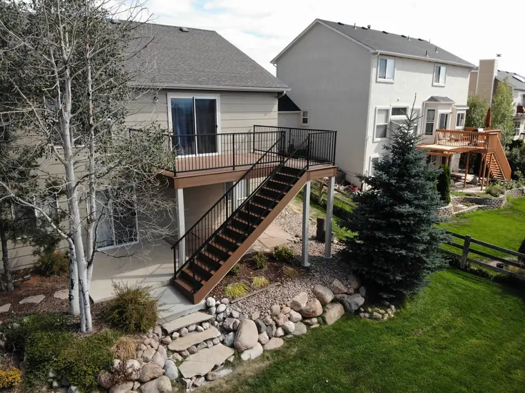 Classic railing on a raised deck and stair seen from the garden