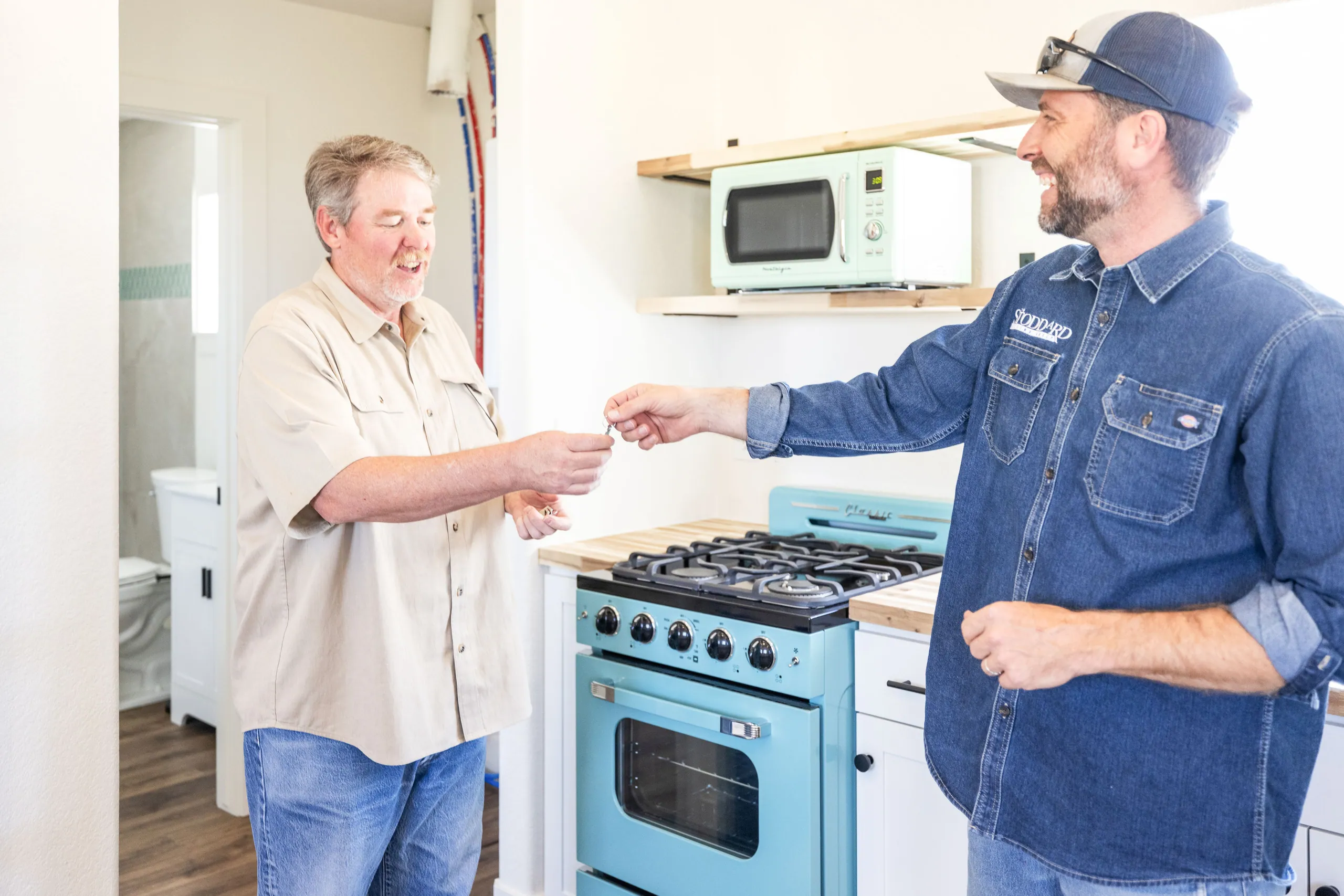 Collin Stoddard handing over the keys to a finished tiny home in Elbert