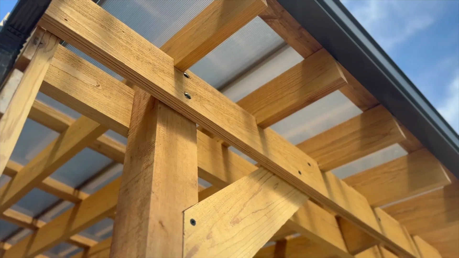 A cedar pergola over a patio and seating area at a Stoddard project
